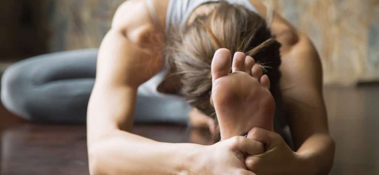 Sportliche Frau dehnt sich macht Yoga